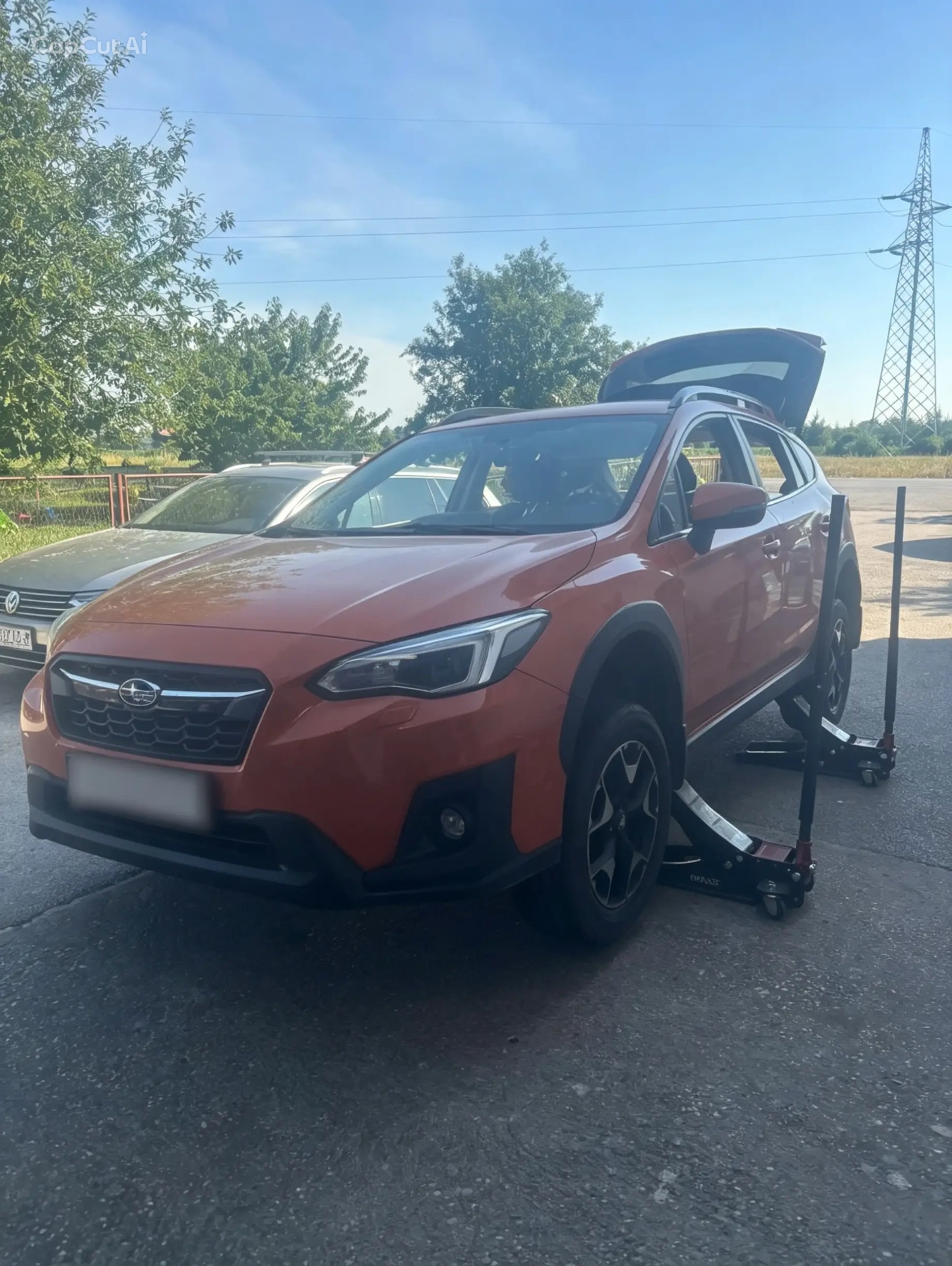 Orange Subaru lifted for tire change